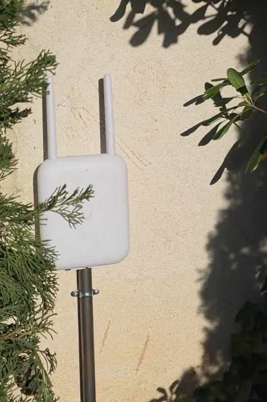 Installation point d'accès WiFi extérieur Ubiquiti UniFi avec passage câbles tube acier — infrastructure réseau outdoor villa prestige Saint-Tropez par Dotix